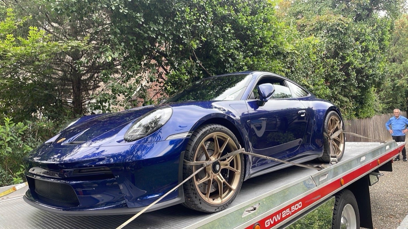 Porsche azul transportado por XXCELL Towing
