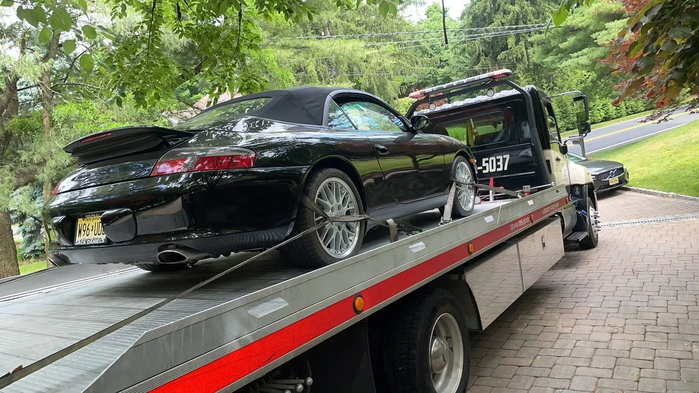 XXCELL Towing flatbed with a black Porsche 911 Cabriolet in Bergen County NJ