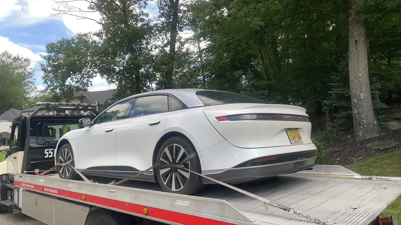 XXCELL Towing flatbed transporting a white Lucid Air EV in Bergen County NJ